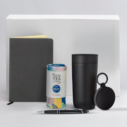 A black drink bottle, a grey notebook, a pen, a tea canister, and a small black accessory with a logo.