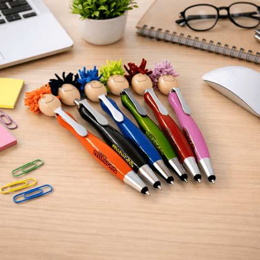 A set of six colourful Mop Head Pens with Stylus, featuring playful character toppers, displayed on a desk.