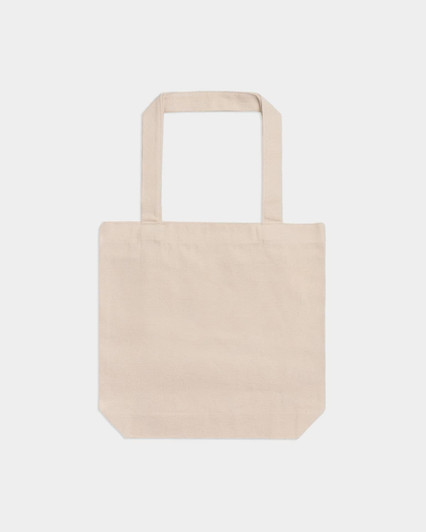 A beige American Apparel tote bag with two shoulder straps and a plain design. It features a logo on one side.