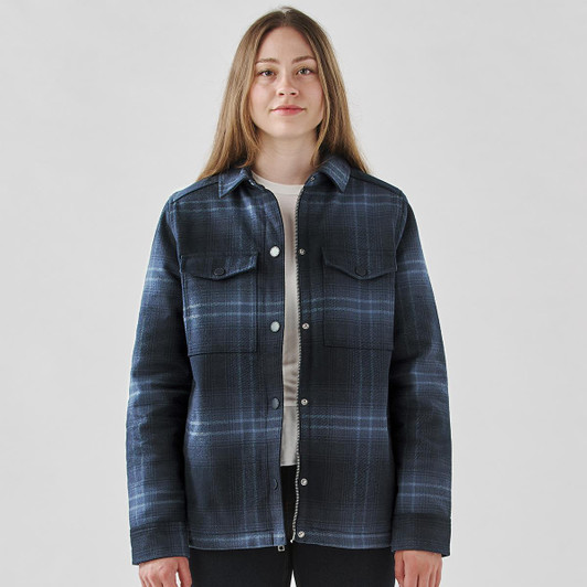 A plaid jacket in navy and blue tones with a Sherpa lining and snap buttons. Features two chest pockets and a logo.