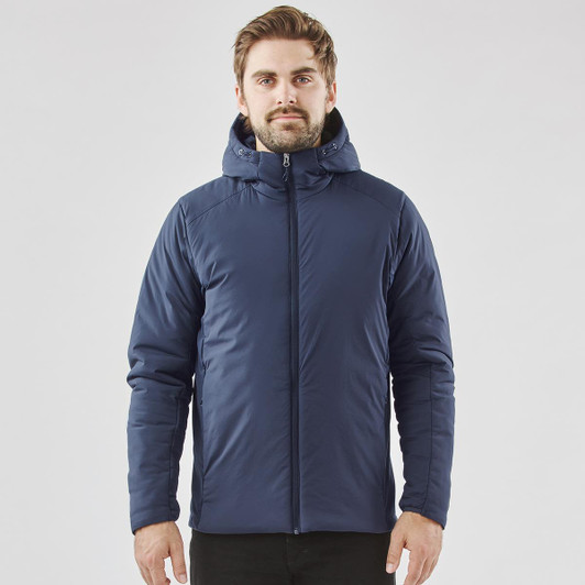 A man wearing a navy blue puffer jacket with a hood, featuring a logo. The jacket has a zip closure and a fitted design.