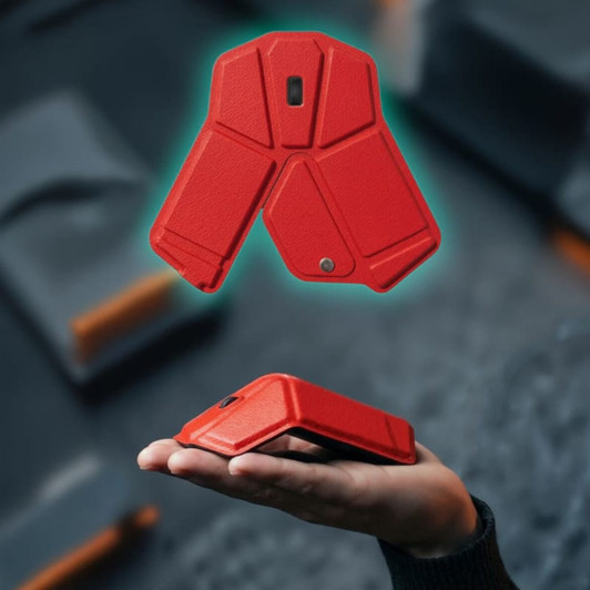 A red foldable wireless mouse resting in a hand, showcasing its compact design and modern aesthetics.