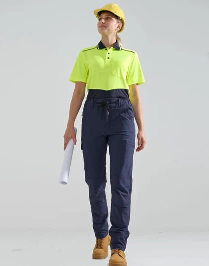 A pair of navy work pants with a flexible fit, worn with a fluorescent yellow polo shirt and a hard hat.