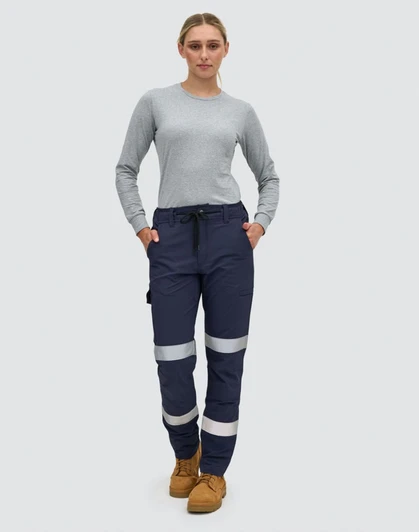 Navy blue work pants with reflective tape, featuring pockets and a comfortable fit, modelled by a woman.