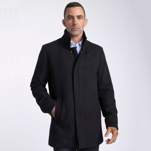 A black wool jacket with a high collar and front pockets, worn by a model against a light background.