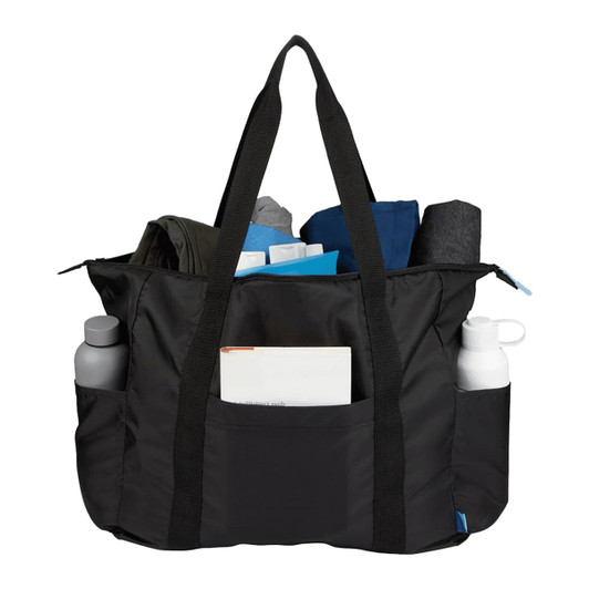 A packable black duffel bag filled with clothing items and bottles, featuring side pockets and sturdy straps.
