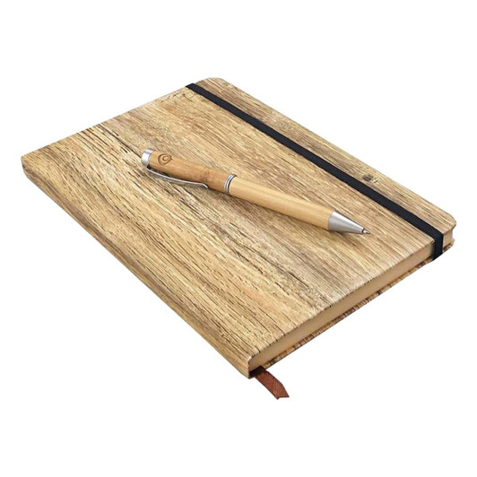 A wood-look notebook with a pen resting on top, featuring a natural finish and an elastic band.