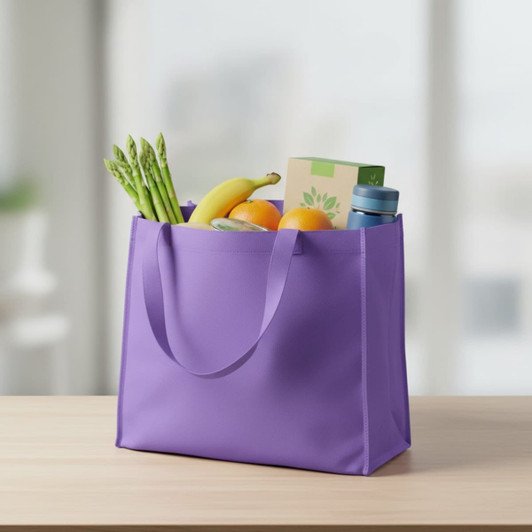 A purple non-woven tote filled with bananas, oranges, asparagus, and a drink bottle. It has two handles.