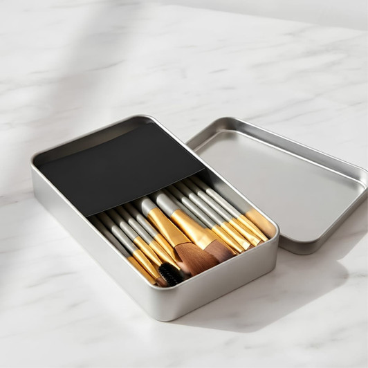 A metal box set containing 12 brushes with silver and gold accents, nestled in a sleek container.