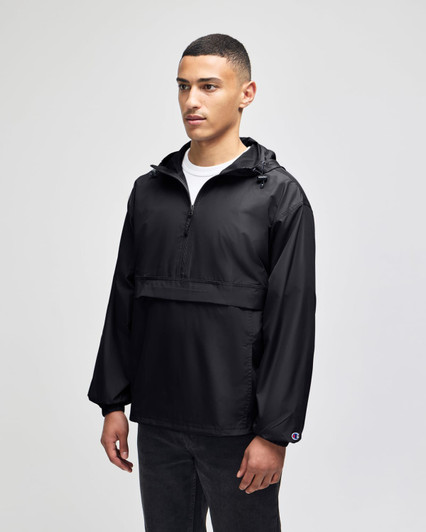 A black packable anorak jacket with a hood, featuring an adjustable drawstring and front pocket, worn by a male model.