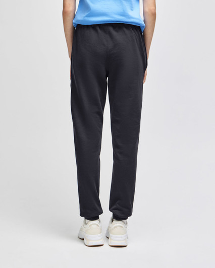Adult fleece joggers in dark grey, featuring an elastic waistband and a logo. Model shown from the back.