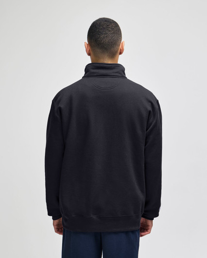 A black quarter-zip pullover with a high collar and a relaxed fit, featuring a logo on the back.