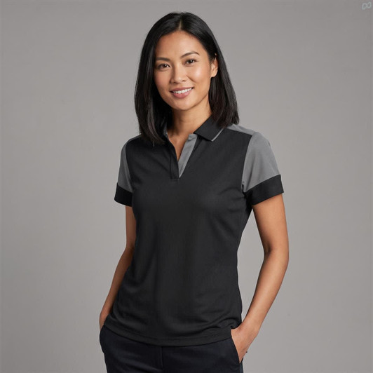 A woman models a women's polo shirt in black with grey accents, featuring a collar and short sleeves.