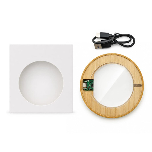A circular bamboo wireless charger in a white square box, with a USB charging cable included.