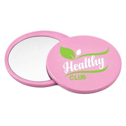 A pink circular makeup mirror with a reflective surface and a logo featuring green design elements.