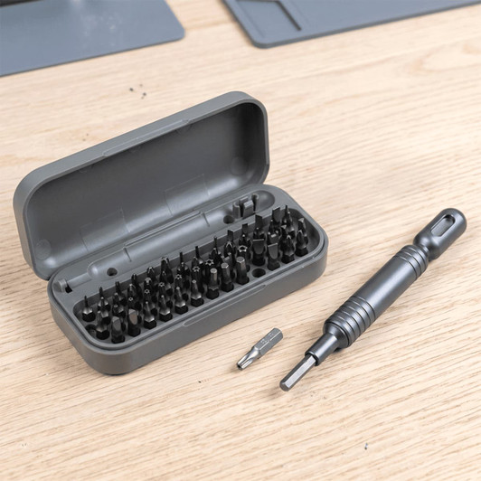 A grey pocket screwdriver tool set with 55 bits, neatly organised in a matching case, alongside a screwdriver handle.