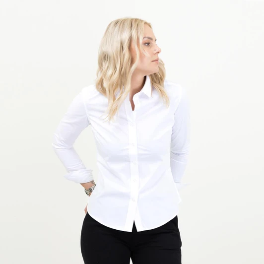 A white women's shirt with long sleeves and a button-up front, worn with black trousers. The model stands facing sideways.