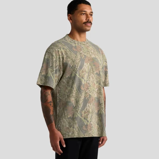 A heavy faded camo tee in shades of green and brown. The shirt has a relaxed fit and features a logo.