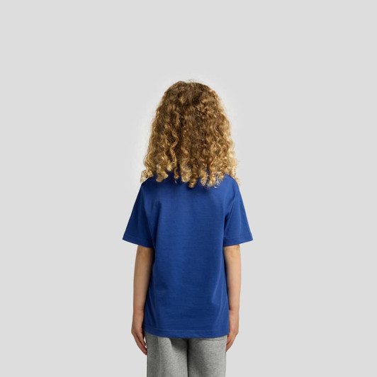 A blue children's T-shirt featuring a plain back design. The model has curly hair and is wearing grey pants.
