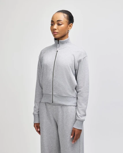 A grey women's full-zip jacket in French terry fabric, featuring a high collar and relaxed fit.