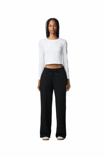 Wide leg pants in black worn with a fitted white long-sleeve top. Features a drawstring waist and a logo.