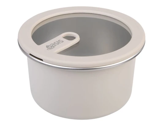 A round, microwave-safe stainless steel container in cream with a clear lid and a handle, featuring a logo.