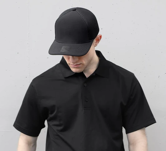 A black polyester/mesh cap with a logo, worn by a person in a matching black polo shirt.