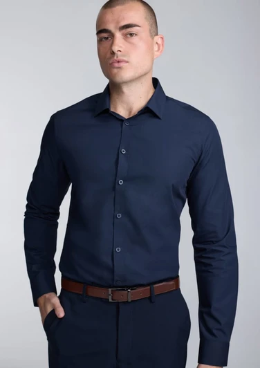 A fitted long sleeve shirt in navy blue, featuring a button-up front and a sleek collar, worn by a model.