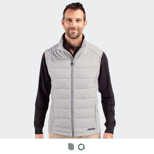 A man wearing a light grey puffer vest, featuring a zip front and a sleek design. The vest has a logo on it.
