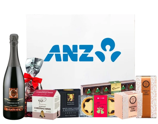 A festive hamper featuring Prosecco, assorted cookies, Christmas treats, and a pudding, presented in a branded box.