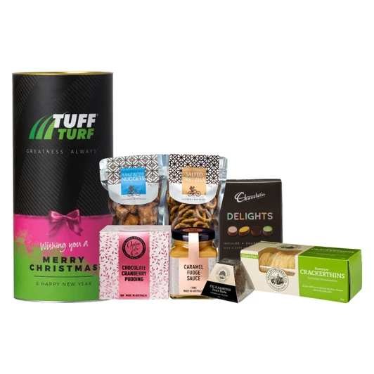 A cylindrical hamper in green and pink containing snacks like praline nuggets, salted pretzels, and fudge sauce.