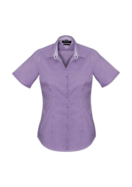 A women's short sleeve button-up shirt in a purple check pattern, featuring a collar and a logo.