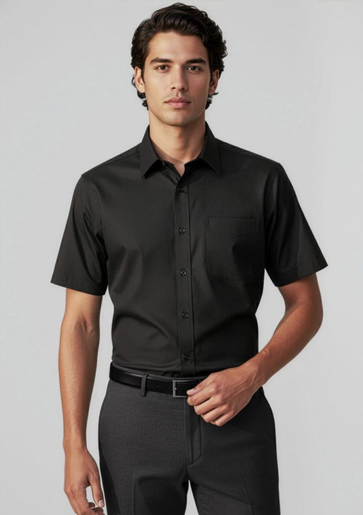 A short-sleeve black button-up shirt on a male model, featuring a chest pocket and a sleek design.