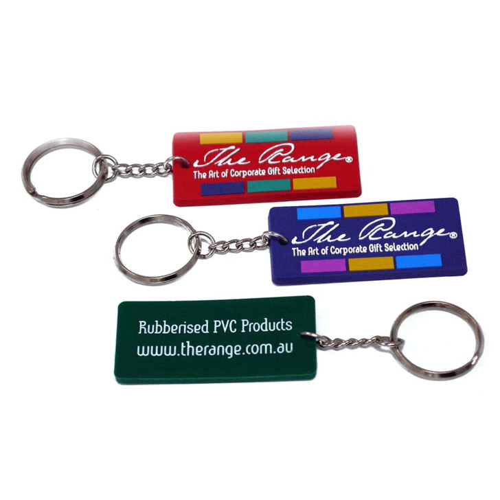 A set of three custom PVC keyrings in red, blue, and green, each with a metal keyring attachment and branding.