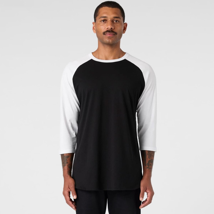 A black and white Raglan Tee featuring a crew neck and three-quarter sleeves, with a logo present.