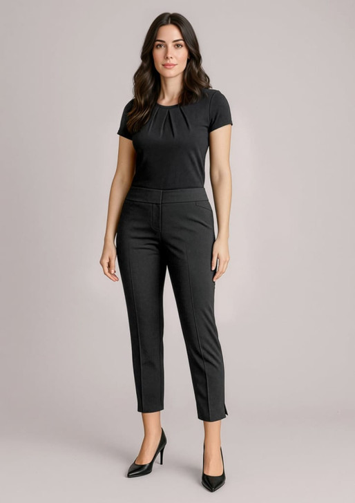 A woman in black slim leg pants paired with a black top, standing in a neutral background. The pants have a mid-waist design.