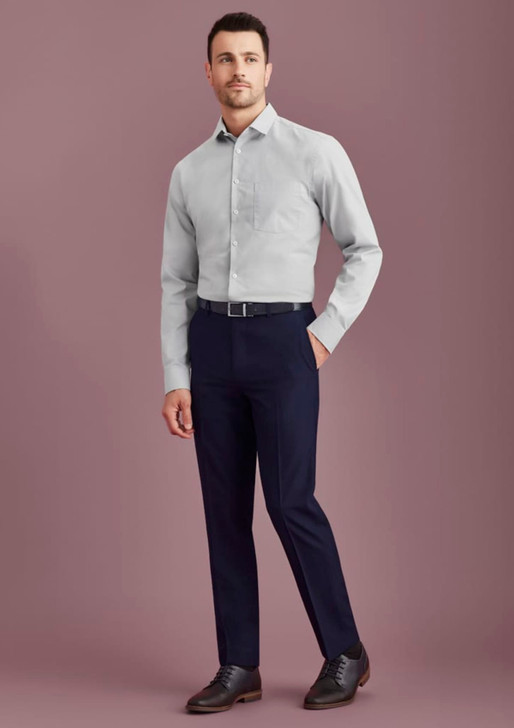 A man wearing a light grey shirt and navy blue slim fit flat front pants, complemented by black shoes and a belt.