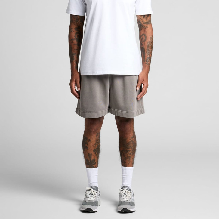 Relaxed grey track shorts with a subtle hem finish, styled on a person wearing a white t-shirt and sports shoes.