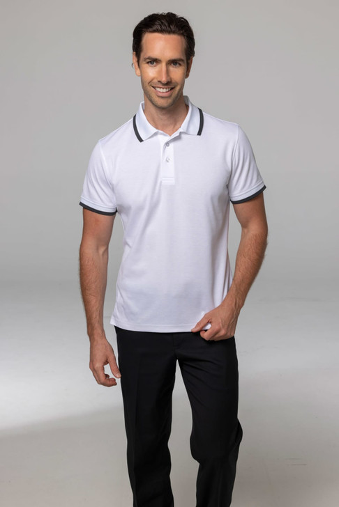 A smiling man wearing a white polo shirt with dark collar and sleeve trims, paired with black trousers.
