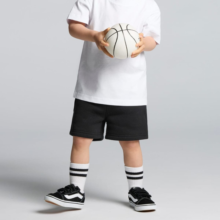 Black track shorts worn with a white T-shirt and black sneakers, holding a basketball. The outfit includes striped socks.