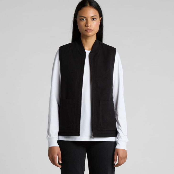 A black heavy vest with two front pockets, worn over a white long-sleeve top. Features branding.