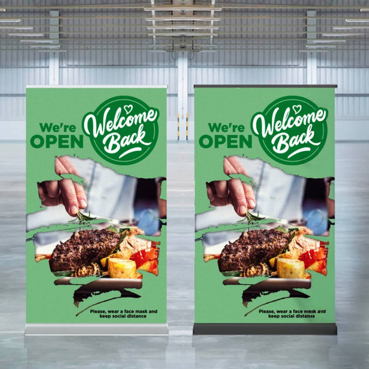 Two luxury pull-up banners in green featuring food imagery and a logo, set in a spacious indoor event space.