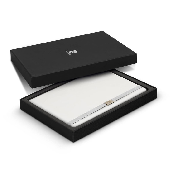 A sleek black gift box containing a white notebook with a metallic strap, featuring a brand logo.