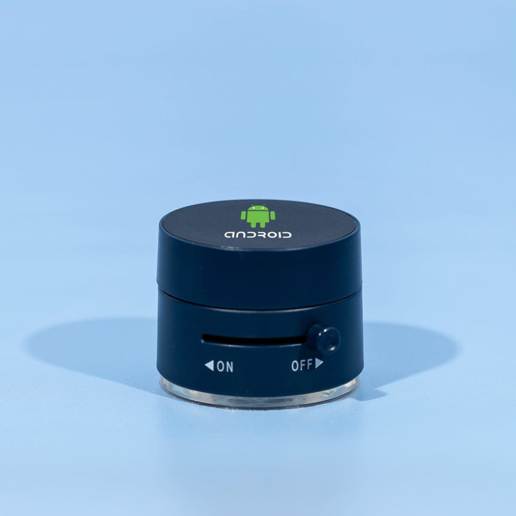 A black and silver device with a logo on top and a dial on the side, resting on a blue background.