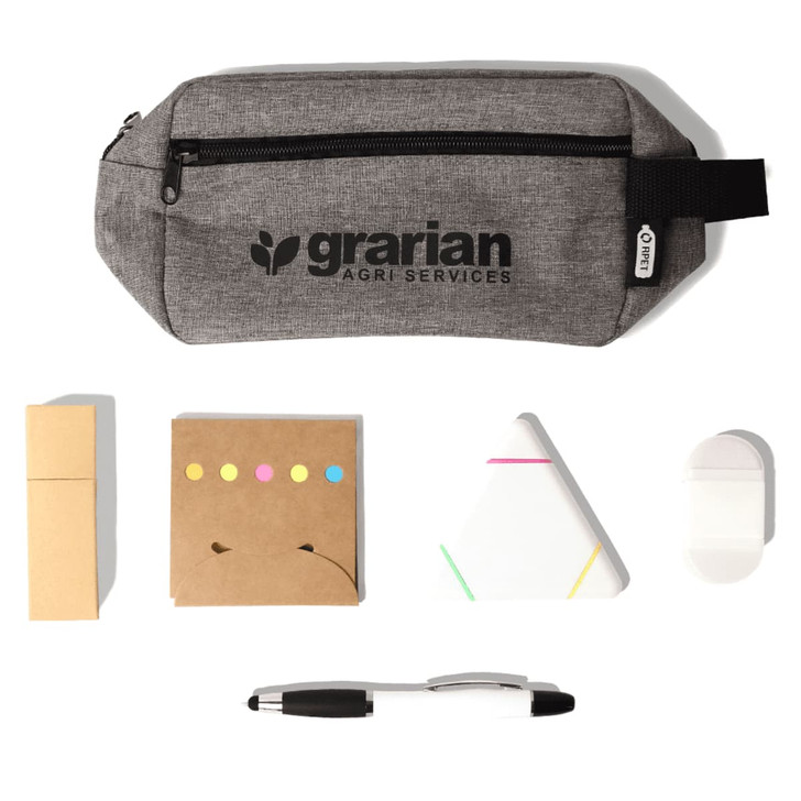 A grey pencil case with a logo contains sticky notes, a triangular notepad, a white eraser, and a black pen.