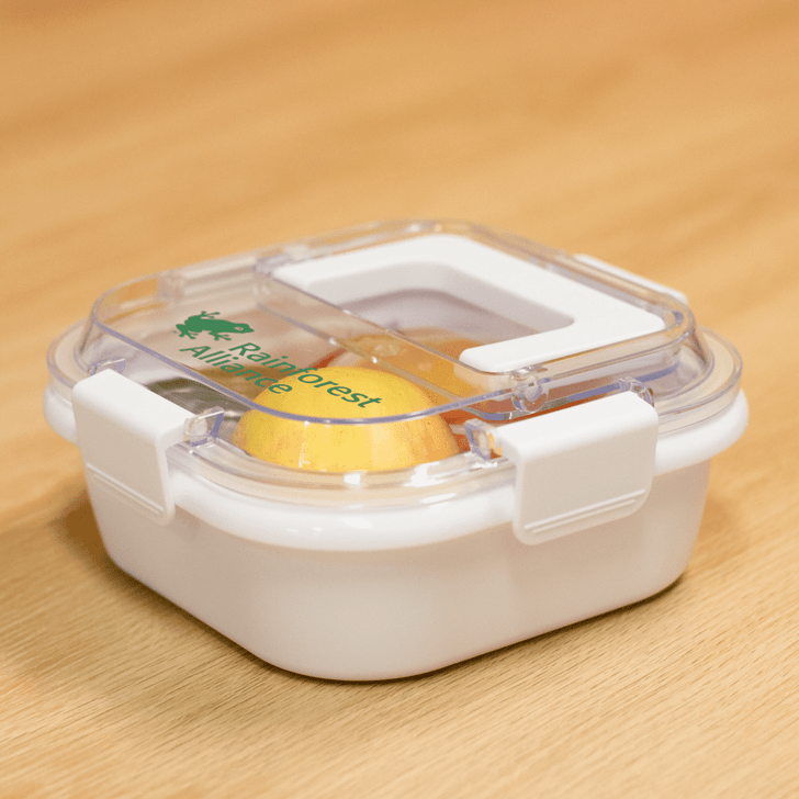 A white lunch box with a clear lid, featuring a green logo and a secure clip closure.