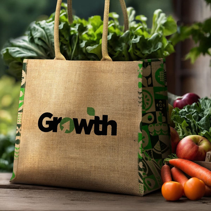A jute tote bag in natural tones with a colourful patterned design and handles, surrounded by fresh vegetables and fruit.