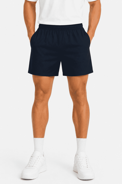 Men's sports shorts in navy blue, featuring an elastic waistband and side pockets. The model is wearing white shoes and socks.