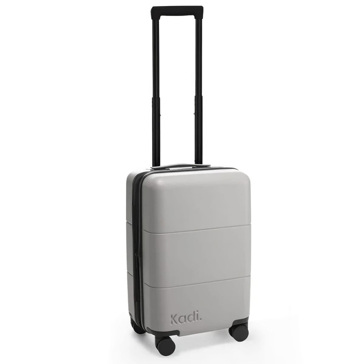 A grey carry-on suitcase with four wheels and a retractable handle, featuring branding on the side.