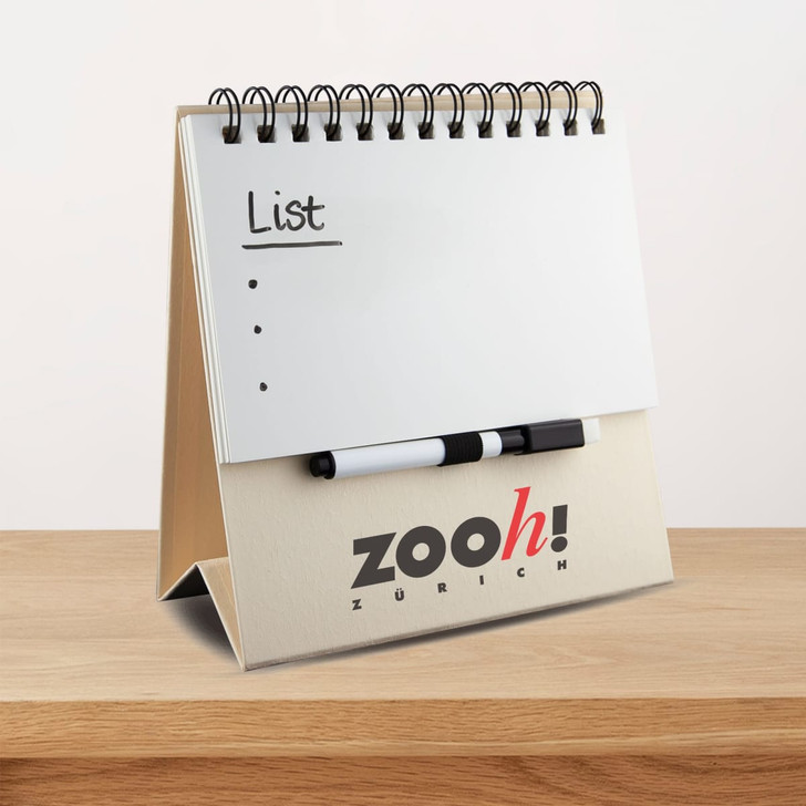 A tabletop notepad with a spiral binding, featuring a plain white notepad and a black marker. It has a logo on the base.